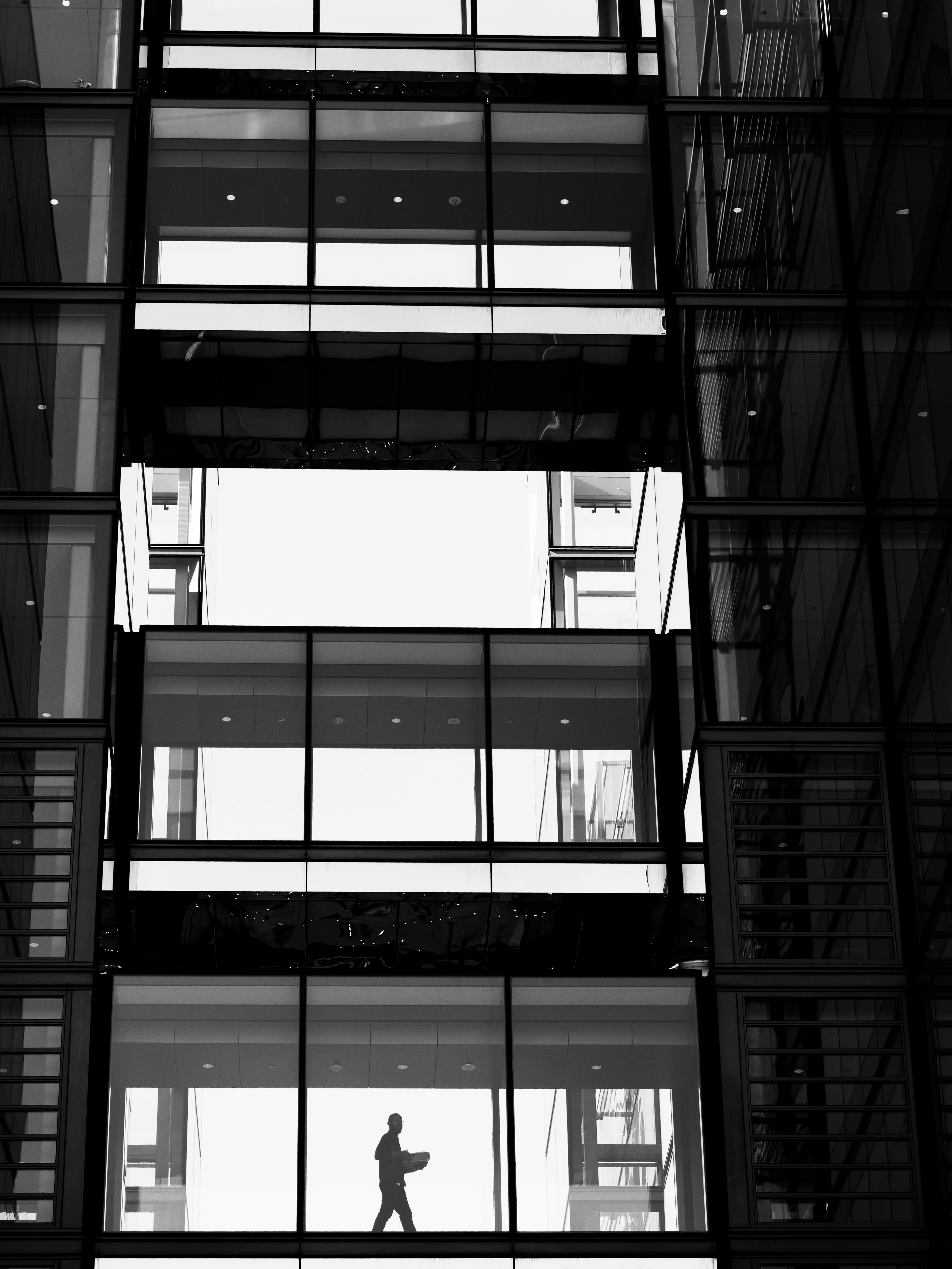 Silhouette of a person walking with a laptop